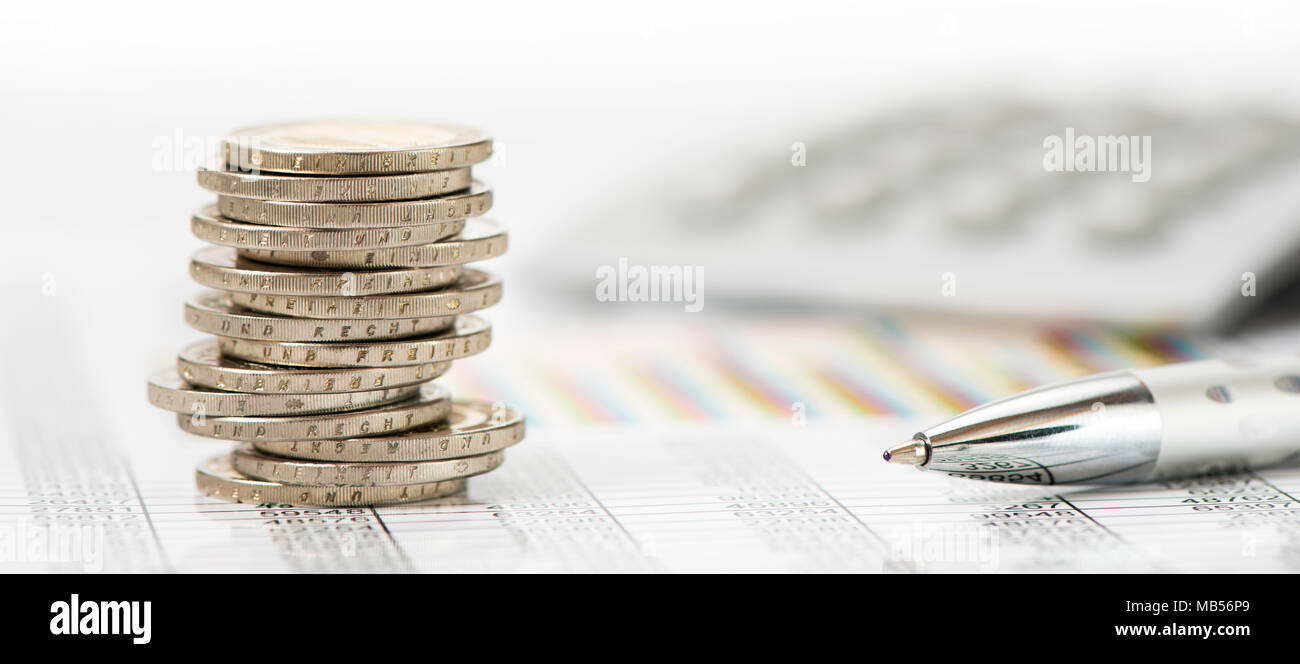 Impilate le monete in euro e la calcolatrice posa su attività finanziarie grafico Foto Stock