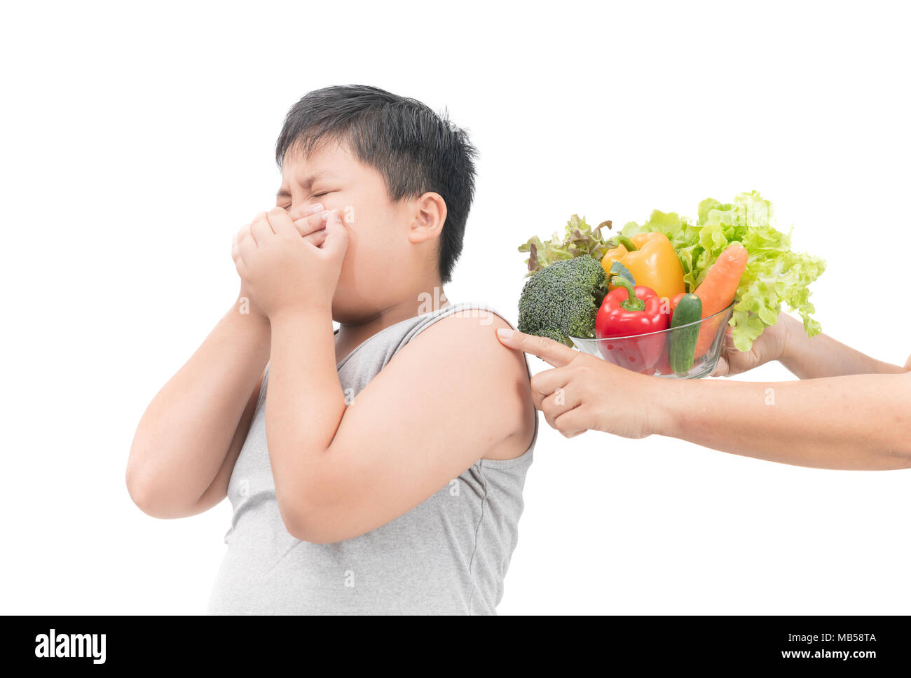 Obesi Fat Boy con espressione di disgusto contro la verdura isolati su sfondo bianco, rifiutando il concetto di cibo Foto Stock