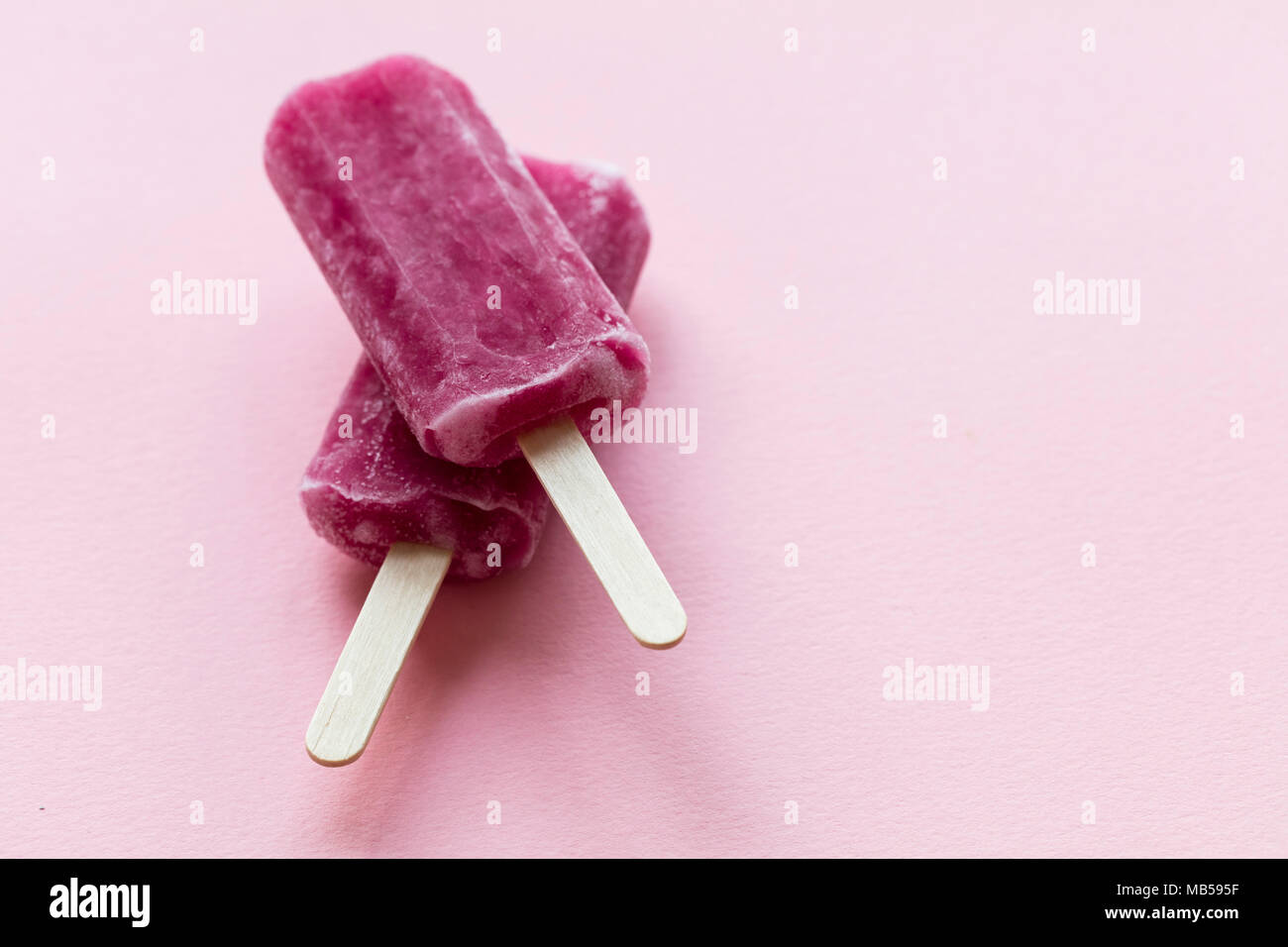 Aroma di lampone estate ghiaccioli su uno sfondo rosa Foto Stock