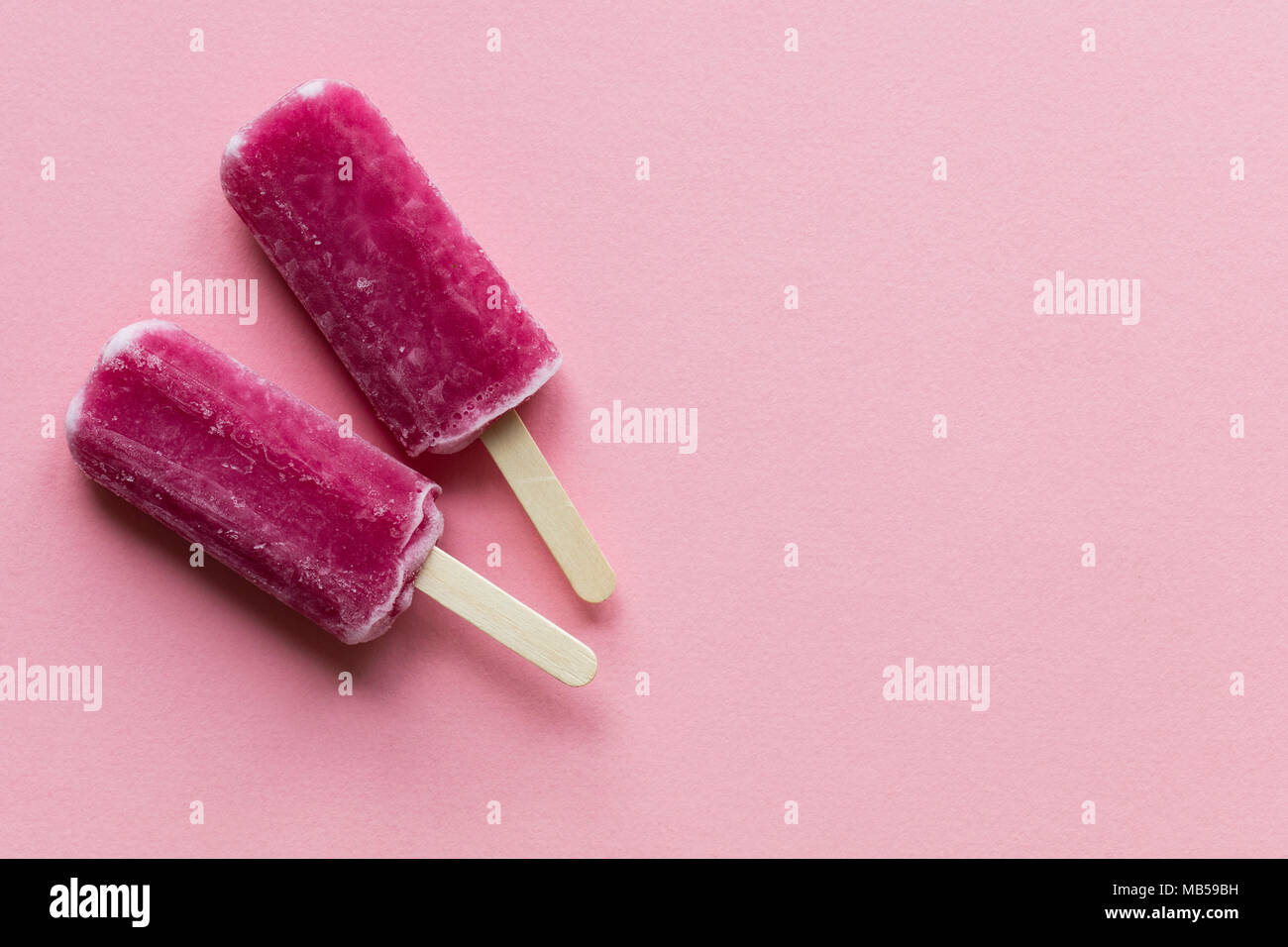 Aroma di lampone estate ghiaccioli su uno sfondo rosa Foto Stock