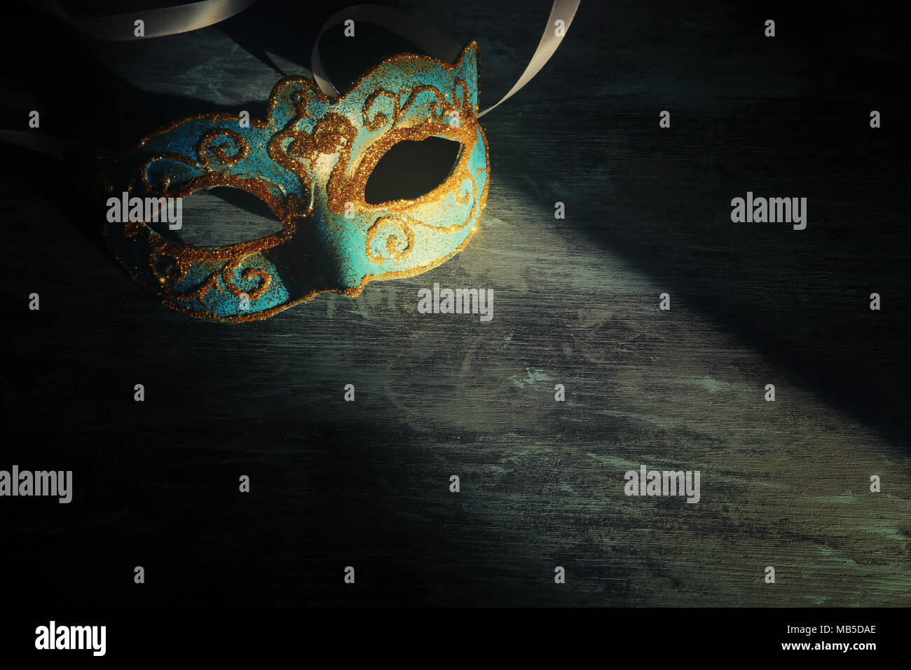 Immagine di elegante blu e oro veneziano, Mardi Gras mask su sfondo scuro Foto Stock
