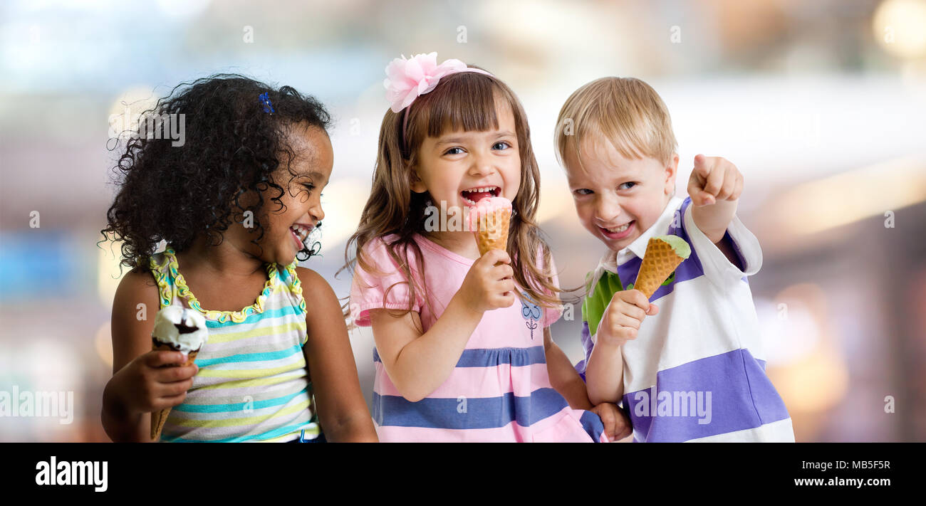 Contenti i bambini a mangiare il gelato in un party in cafe Foto Stock