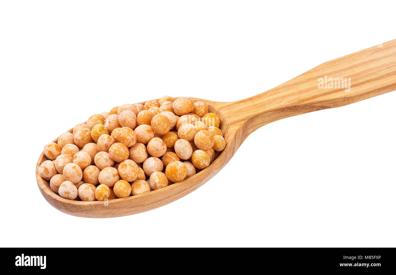 Piselli secchi in cucchiaio di legno isolato su sfondo bianco. Foto Stock