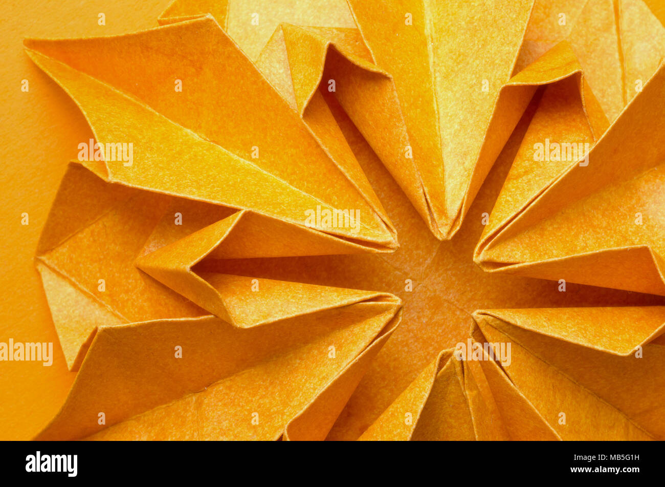 Abstract closeup di una trama radiale arancio fiori di carta Foto Stock