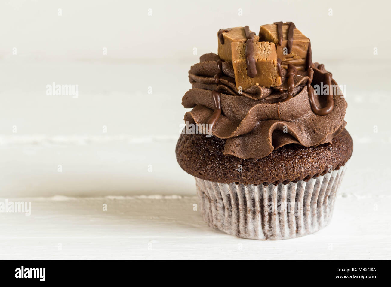 Tortina di cioccolato decorate con mini fudge piazze su bianco tavolo rustico close up Foto Stock