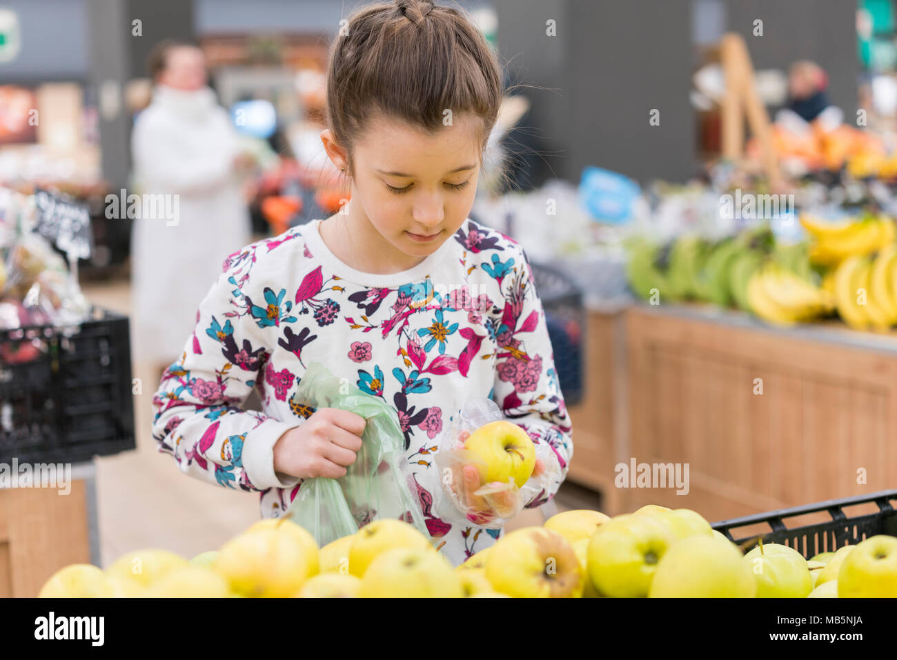 Bambina scelta di mele mature in un negozio di generi alimentari o supermercati. Foto Stock