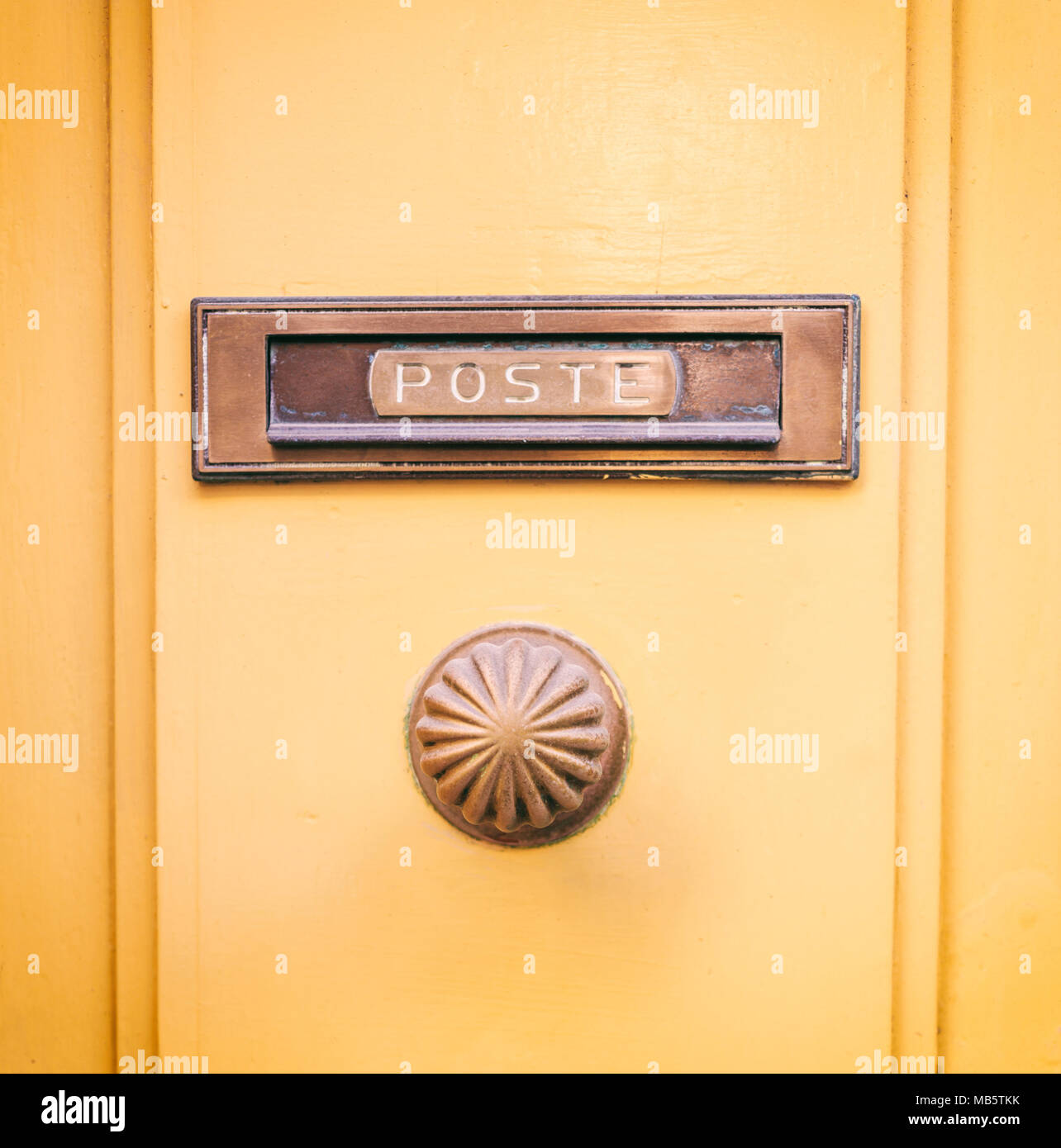 Ottone antico mail letter box e manopola dello sportello su un giallo porta anteriore, testo poste Foto Stock