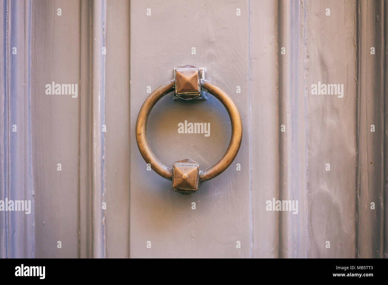 Ottone antico porta respingente, forma ad anello, su un dipinto di grigio dello sportello anteriore Foto Stock