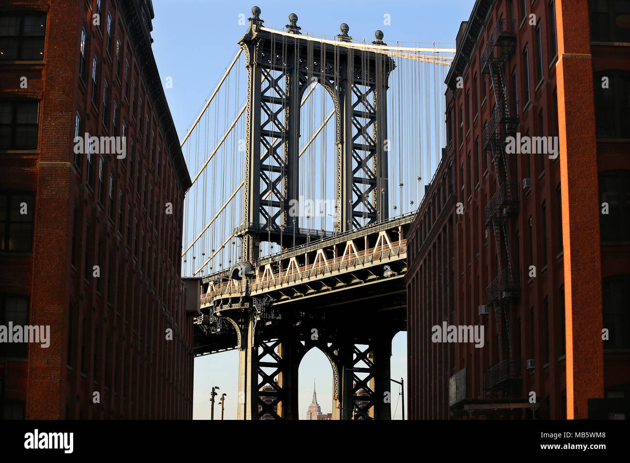 Manhattan Bridge come si vede da Dumbo, Brooklyn con la parte superiore dell'Empire State Building visibile nella città di New York, Stati Uniti d'America Foto Stock