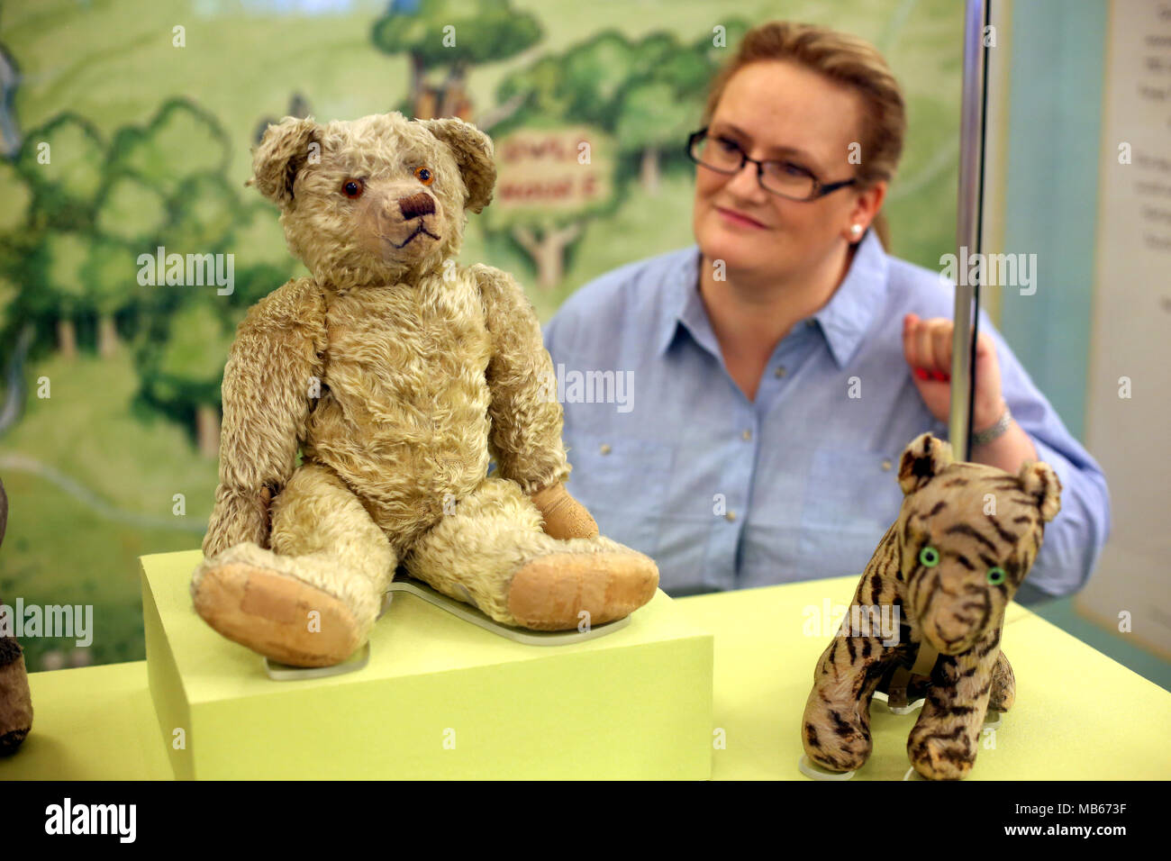 Un visitatore alla Biblioteca Pubblica di New York esamina l'originale Pooh orso che è sul display nella sezione per bambini della libreria nella città di New York Foto Stock