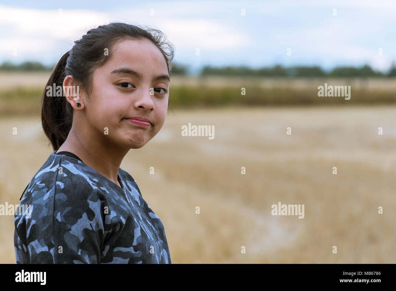 Ragazza giovane esplorando in un campo dopo un raccolto Foto Stock