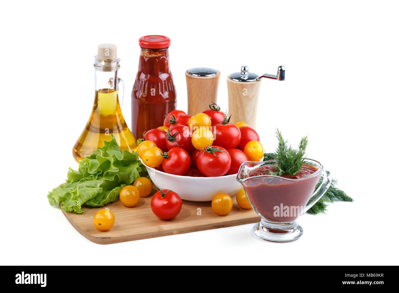 Ancora la vita di rosso e giallo pomodori, bottiglia di salsa di pomodoro e olio di oliva su sfondo bianco. Foto Stock