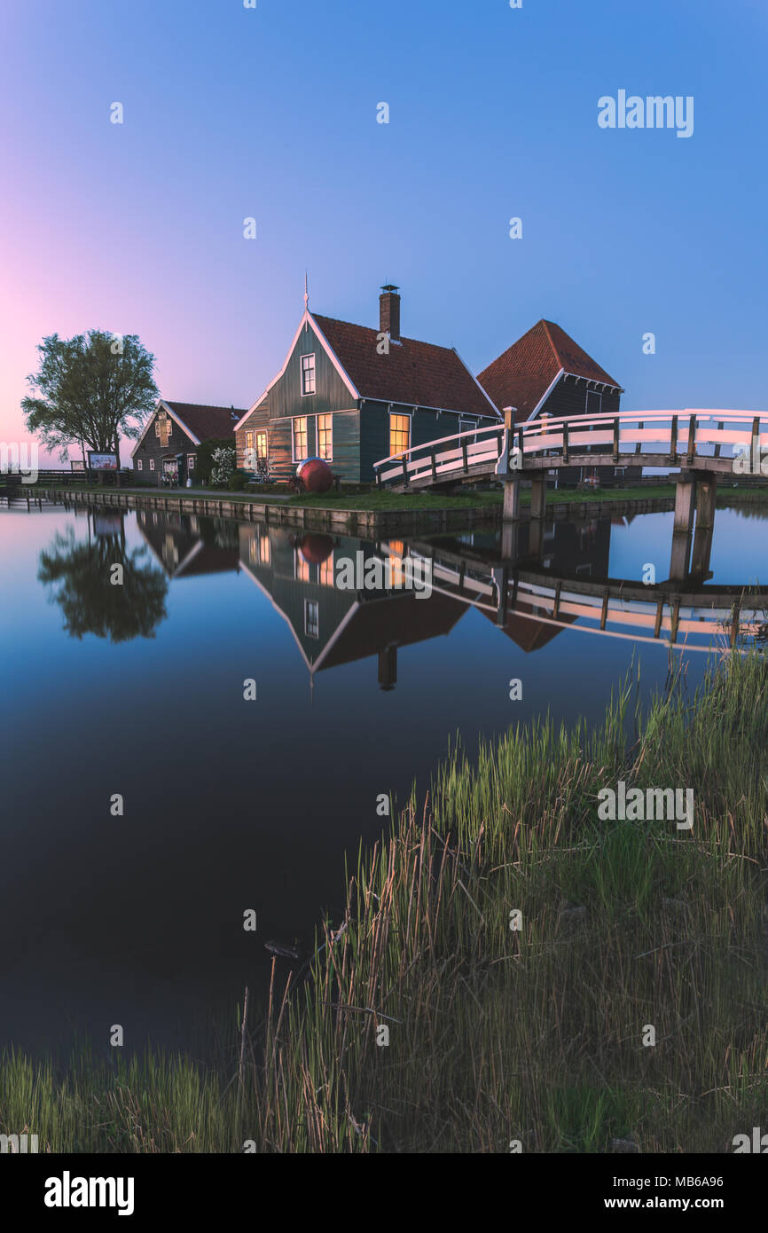 Case in legno è riflessa nelle acque blu del fiume Zaan Zaanse Schans Olanda settentrionale dei Paesi Bassi in Europa Foto Stock