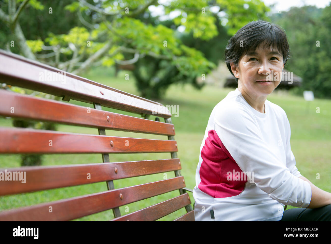 Senior donna asiatica in posizione di parcheggio Foto Stock