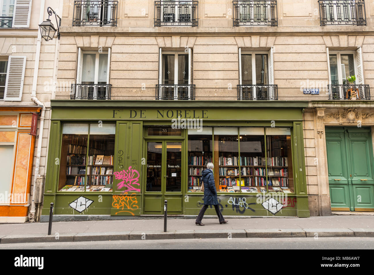 Un uomo che cammina fuori la Librairie de Nobele, 35 Rue Bonaparte, Parigi Foto Stock