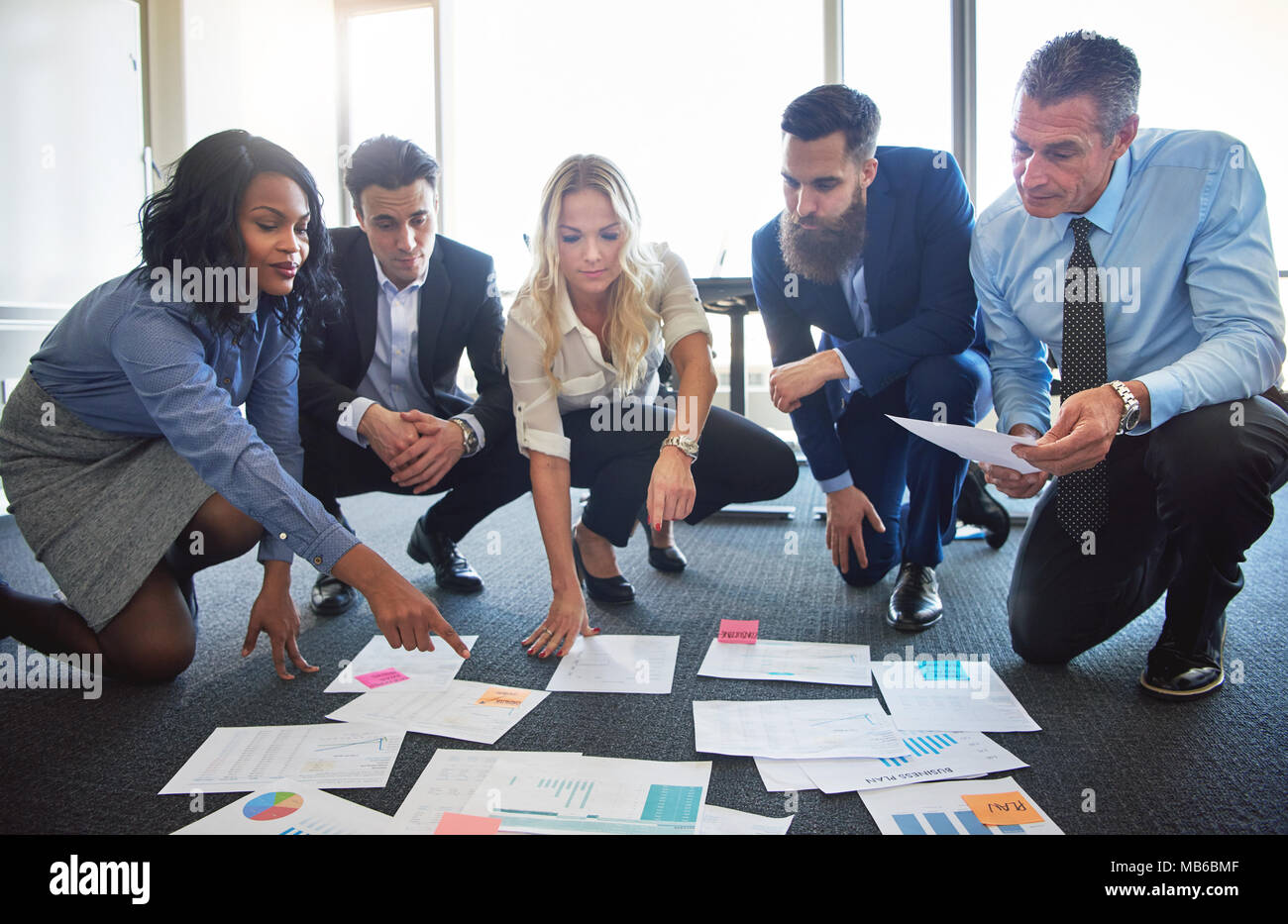 Il team di Business accovacciato in office discutere idee differenti Foto Stock