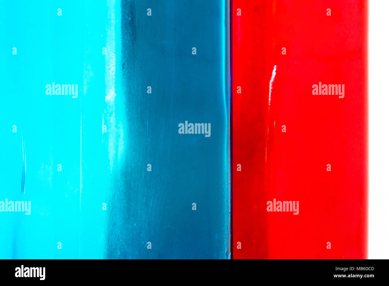 Blu e rosso di vetro superficie di sfondo si connette ogni altro nel mezzo e diventare color grigio scuro Foto Stock