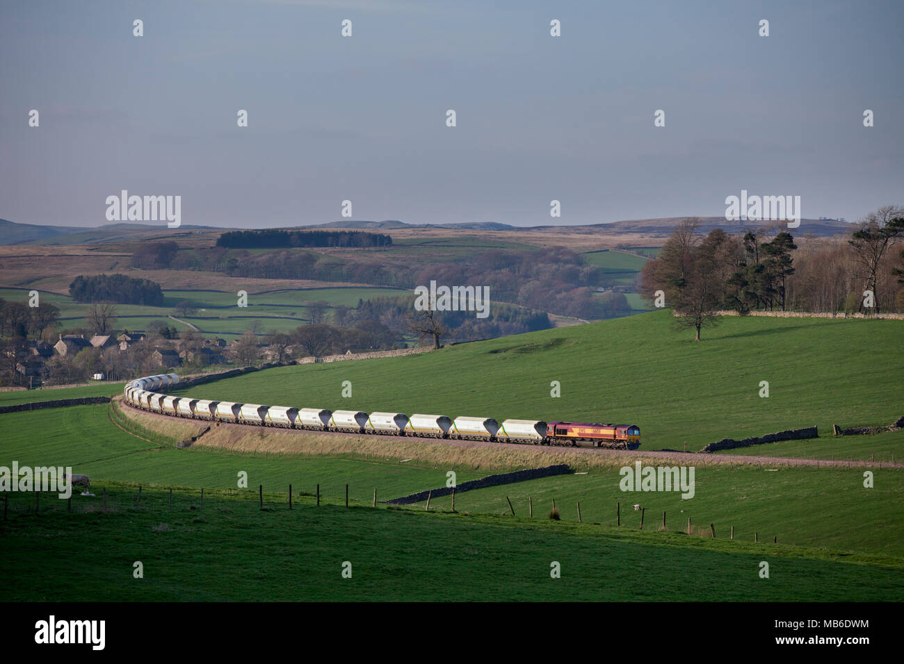 Un DB Cargo classe 66 locomotore trasporta un treno di aggregati da Grassington sul trasporto merci Rylstone derivazione di linea nelle vicinanze Skipton, Yorkshire Foto Stock