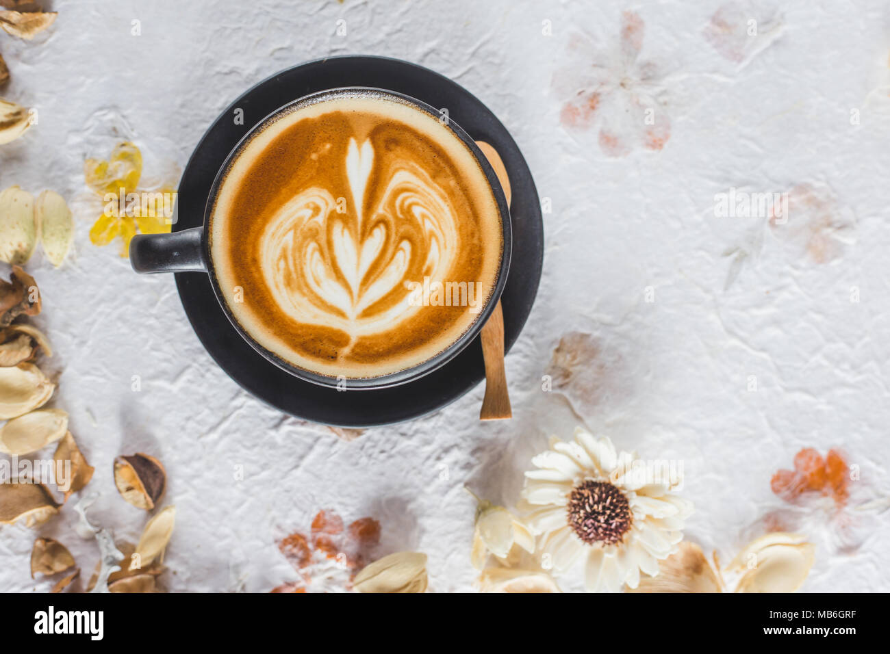 Una tazza di latte caldo art caffè essiccata su carta di fiori Foto Stock