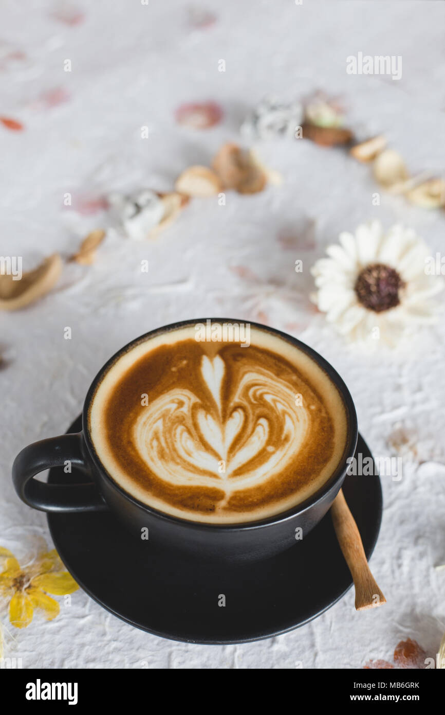Una tazza di latte caldo art caffè essiccata su carta di fiori Foto Stock