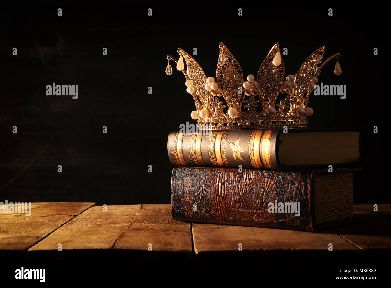 Tasto basso immagine di splendida queen/king corona su vecchi libri. fantasy periodo medievale. Messa a fuoco selettiva Foto Stock