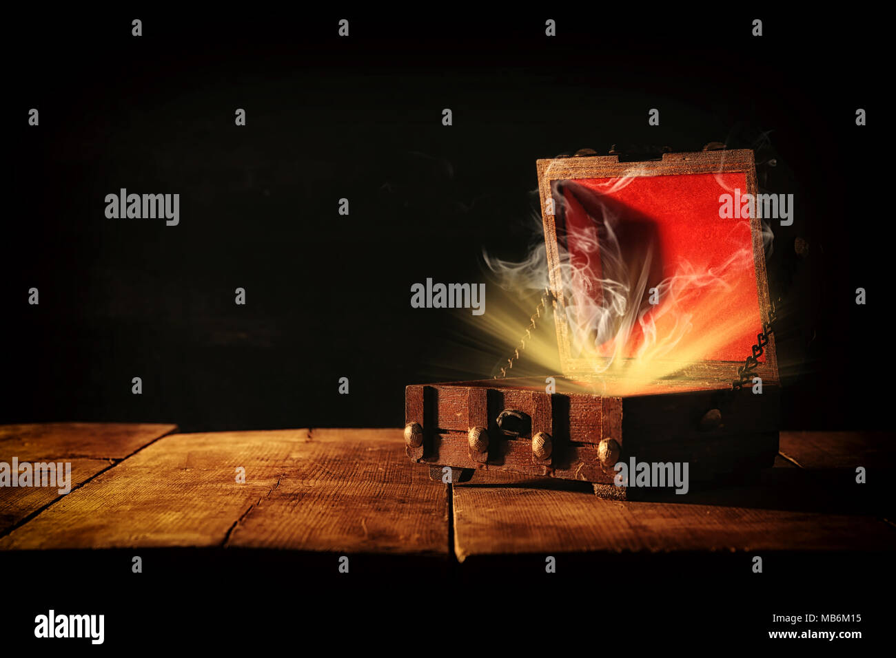 Immagine del misterioso tesoro con la luce e il fumo in legno vecchio tavolo Foto Stock