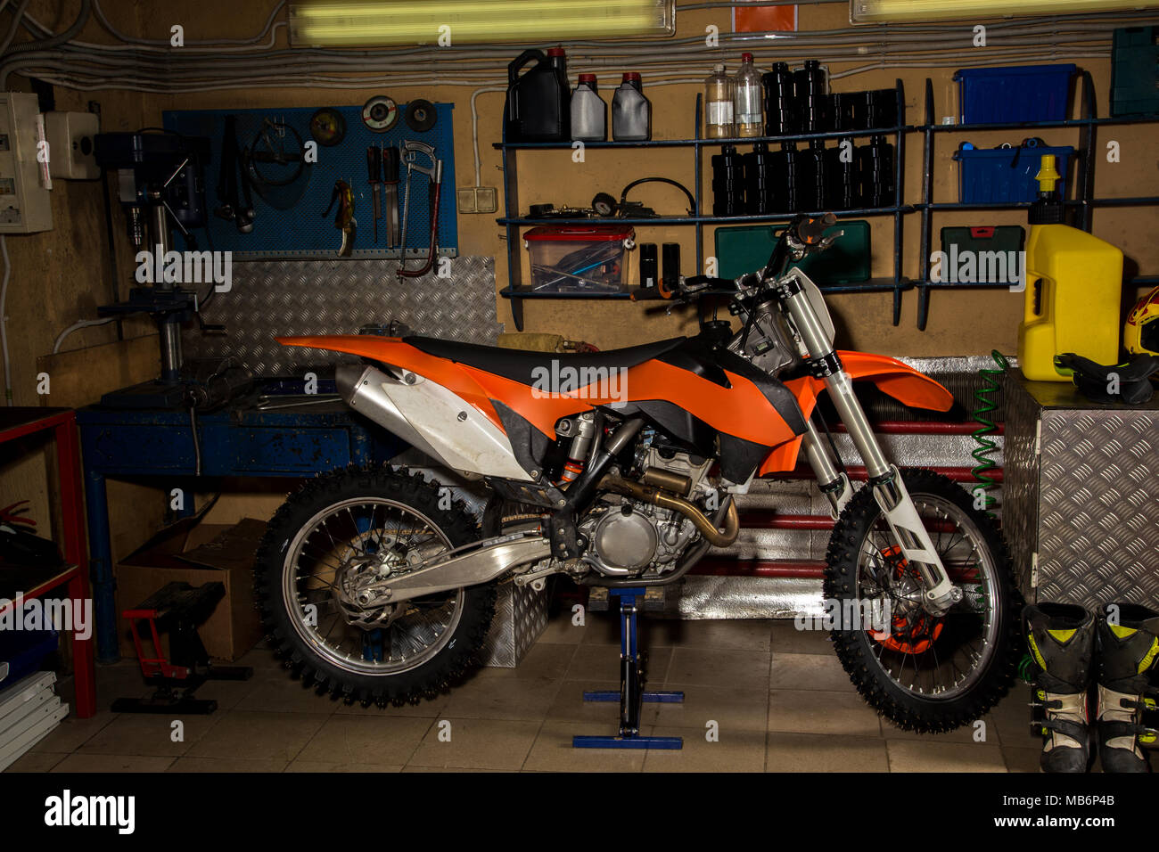 Moto trasversale in piedi in garage con strumenti Foto Stock