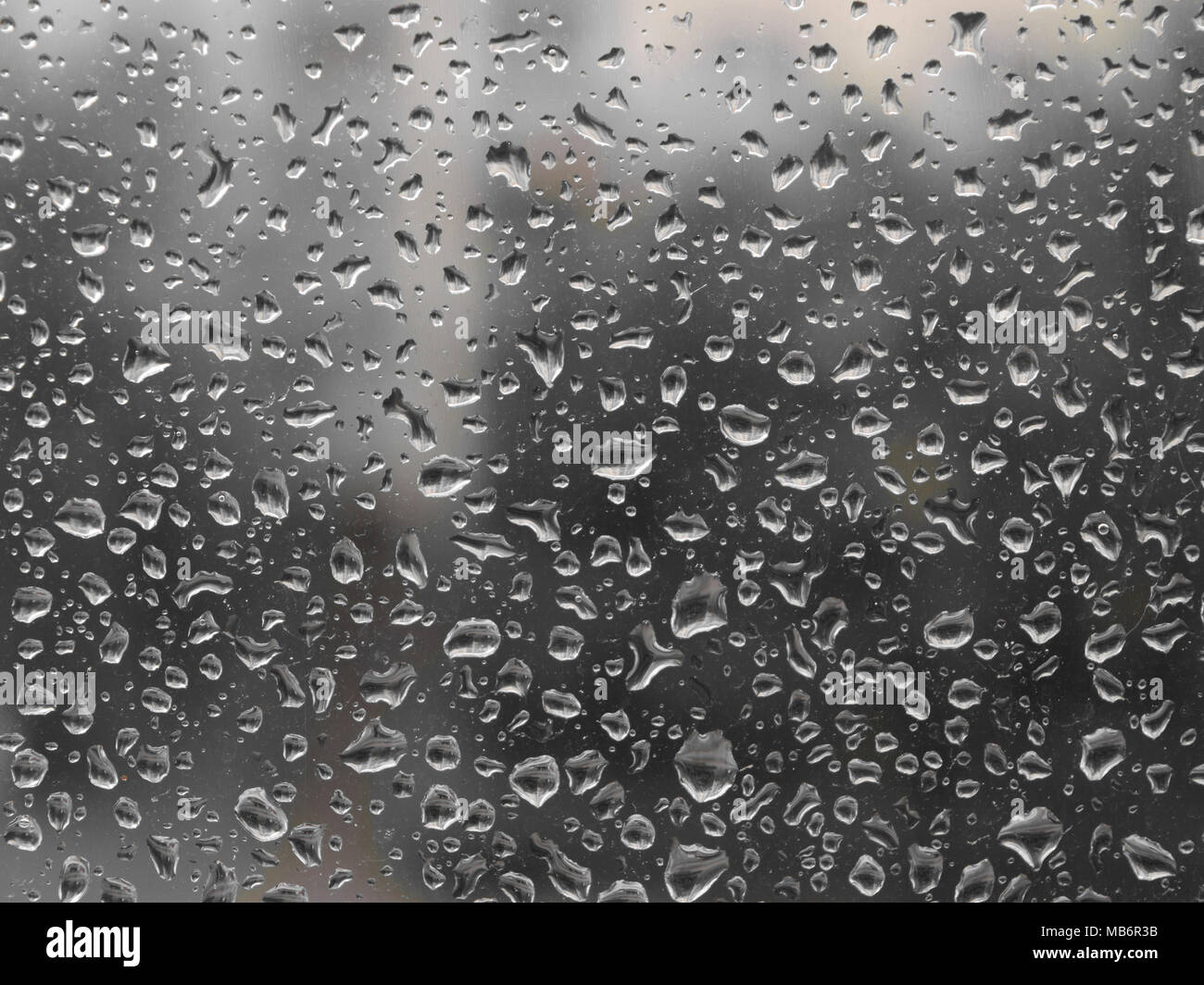 Grigia giornata piovosa. Gocce di pioggia sul vetro. Sfondo Foto Stock