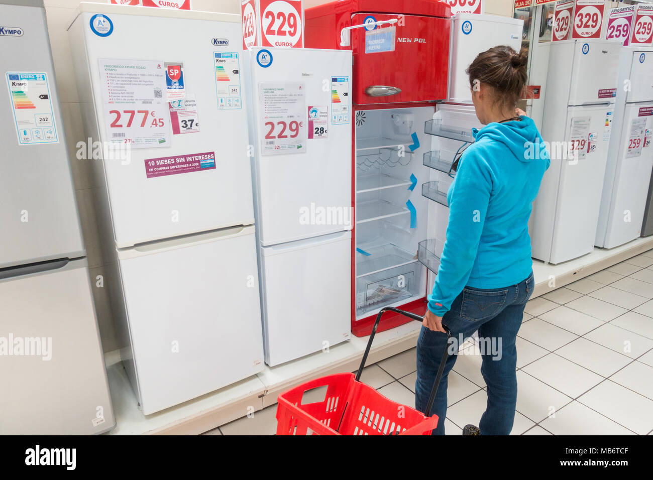 Donna che guarda al nuovo frigorifero/frigoriferi/frigorifero con congelatore in negozio elettrico Foto Stock