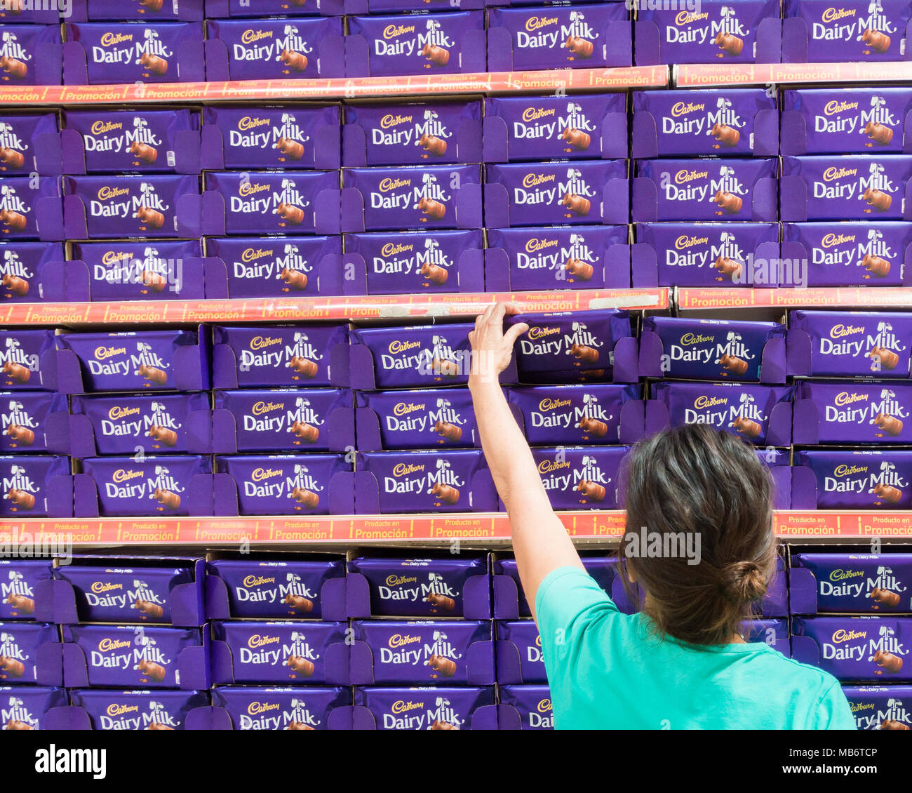 Donna selezionando Cadbury cioccolato al latte bar dal supermercato display. Foto Stock