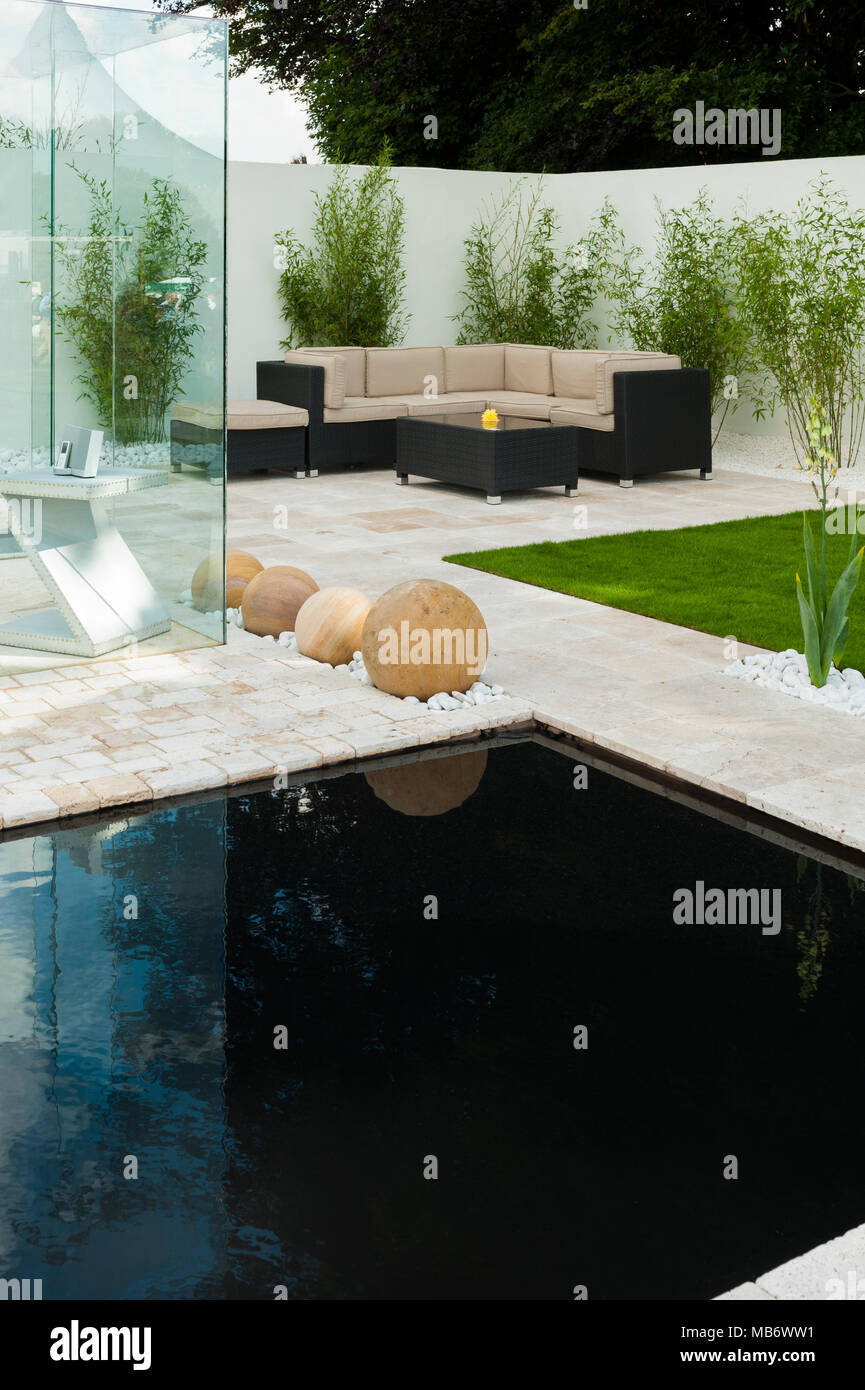 & Minimalista contemporaneo, "respirare" mostra giardino con patio elegante, area salotto, stagno & pietra sfere - RHS Flower Show, Tatton Park, Inghilterra, Regno Unito. Foto Stock