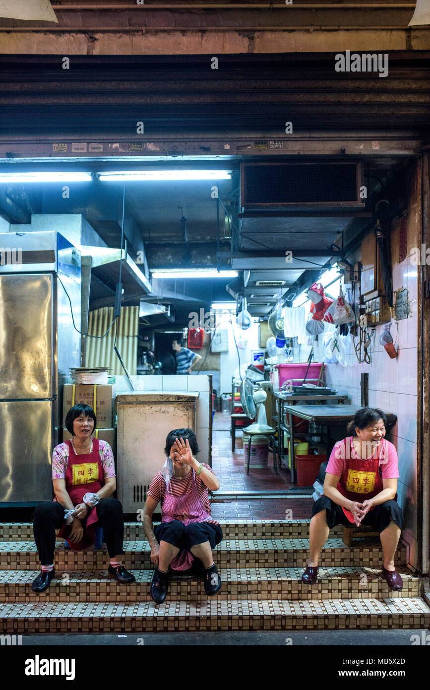 La donna seduta di fronte al negozio di notte in Hong Kong Kowloon Foto Stock