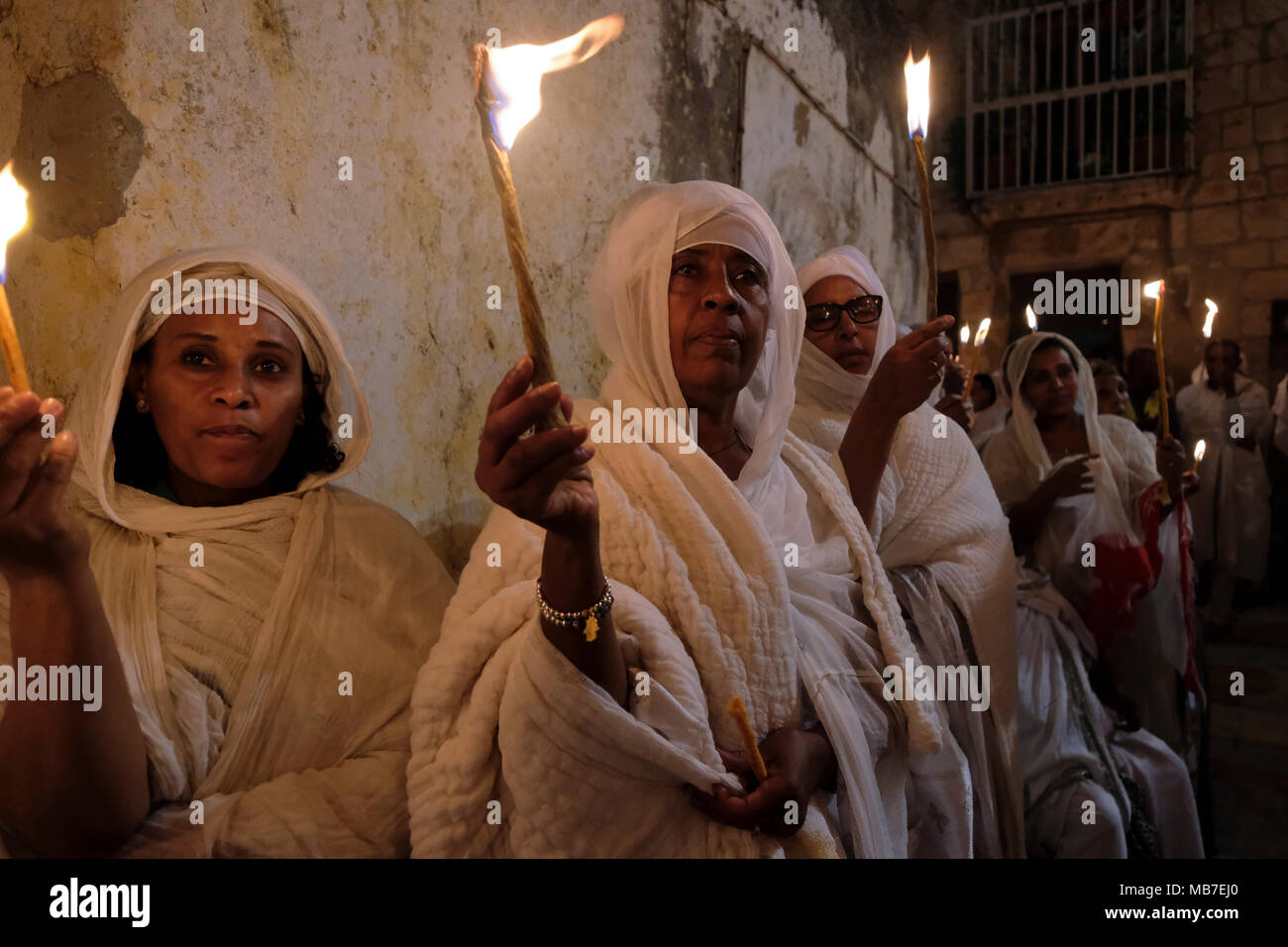 I cristiani ortodossi etiopi tengono candele durante la cerimonia del fuoco Santo al monastero di Deir El-Sultan situato sul tetto della Chiesa del Santo Sepolcro nella Città Vecchia Gerusalemme Est Israele. I cristiani etiopi commemorano gli eventi attorno alla crocifissione di Gesù Cristo, portando alla sua risurrezione nella Pasqua, che in lingua amarica, è chiamata Fasika, originata dalla parola greca Pascha. Foto Stock