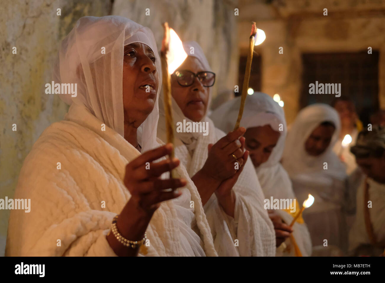 I cristiani ortodossi etiopi tengono candele durante la cerimonia del fuoco Santo al monastero di Deir El-Sultan situato sul tetto della Chiesa del Santo Sepolcro nella Città Vecchia Gerusalemme Est Israele. I cristiani etiopi commemorano gli eventi attorno alla crocifissione di Gesù Cristo, portando alla sua risurrezione nella Pasqua, che in lingua amarica, è chiamata Fasika, originata dalla parola greca Pascha. Foto Stock