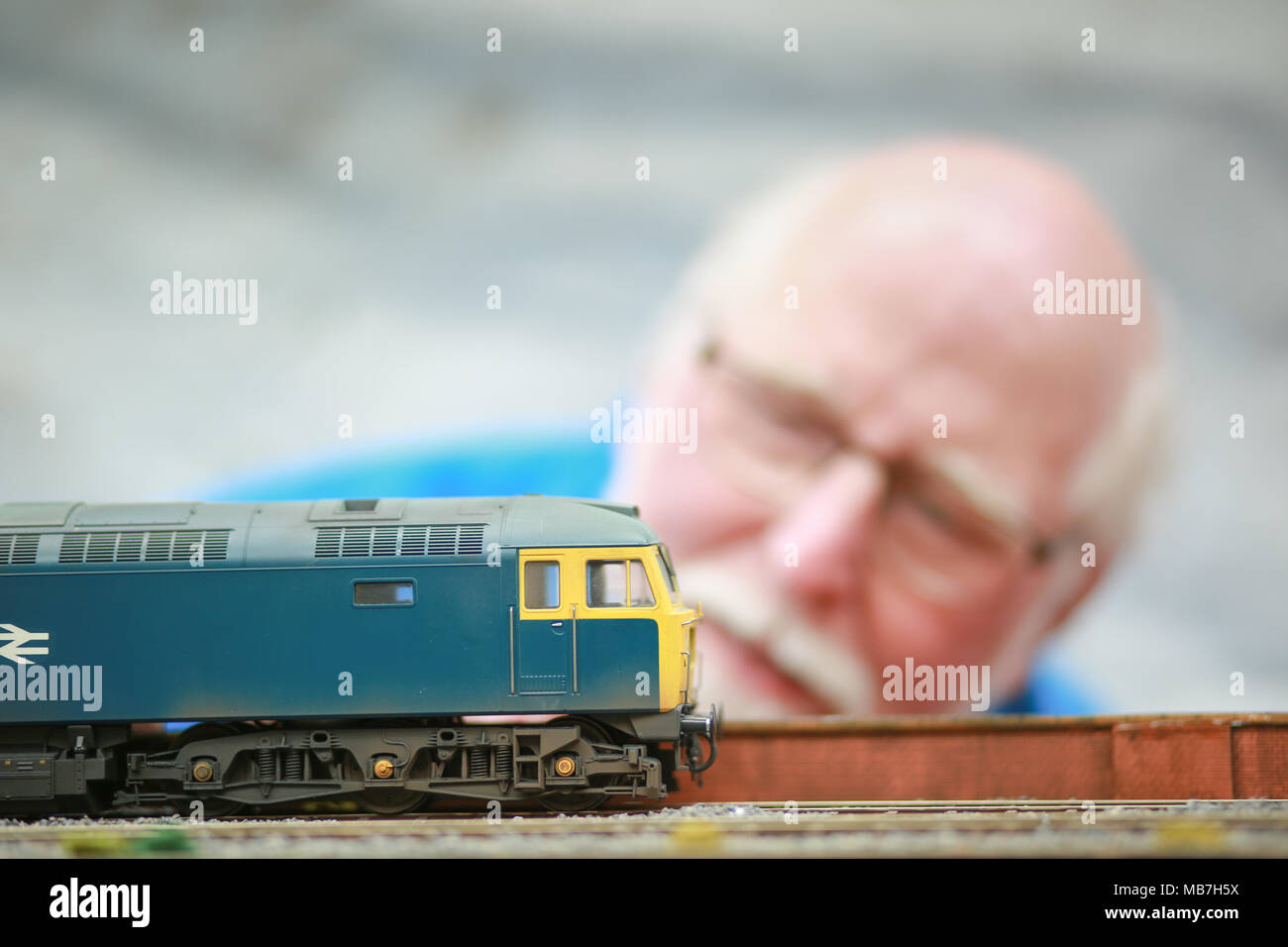 Modello di appassionati ferroviaria godendo il loro modello di layout ferroviarie Foto Stock