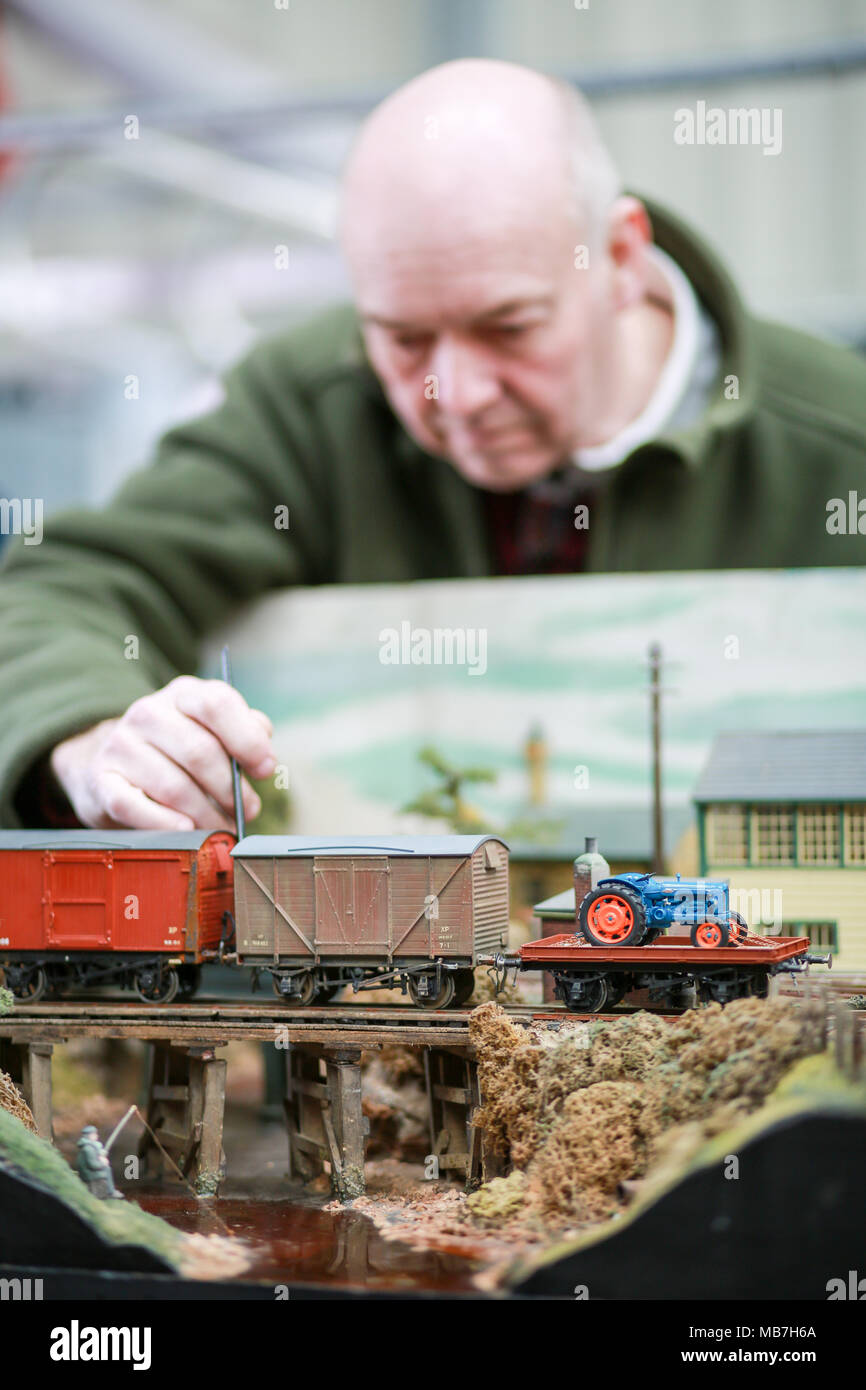 Modello di appassionati ferroviaria godendo il loro modello di layout ferroviarie Foto Stock