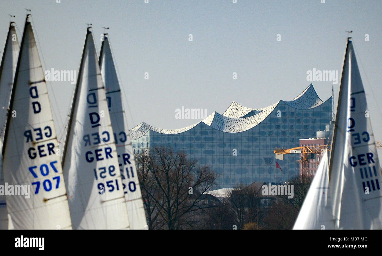 08 aprile 2018, Germania Amburgo: barche a vela sul Alster esterno ed il lago nelle giornate di sole. L'Elbe Philharmonic Hall può essere visto in background. Foto: Axel Heimken/dpa Foto Stock