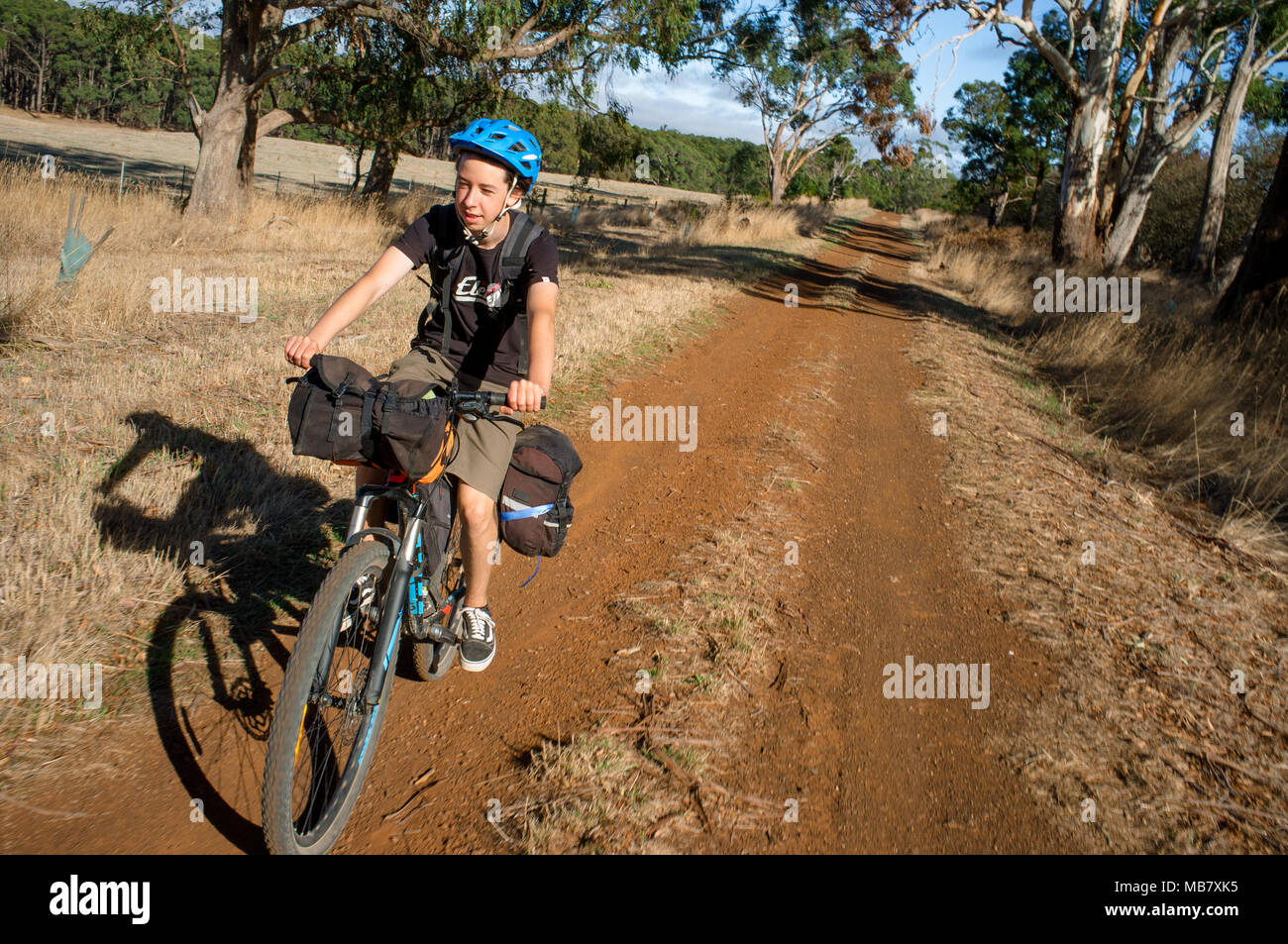 Un ragazzo adolescente corse in mountain bike su una bici avventura di imballaggio in Australia. Foto Stock