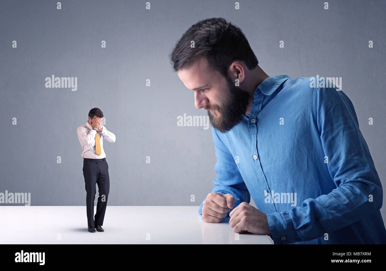 Giovane imprenditore professionale essendo arrabbiato con un altro imprenditore in miniatura Foto Stock