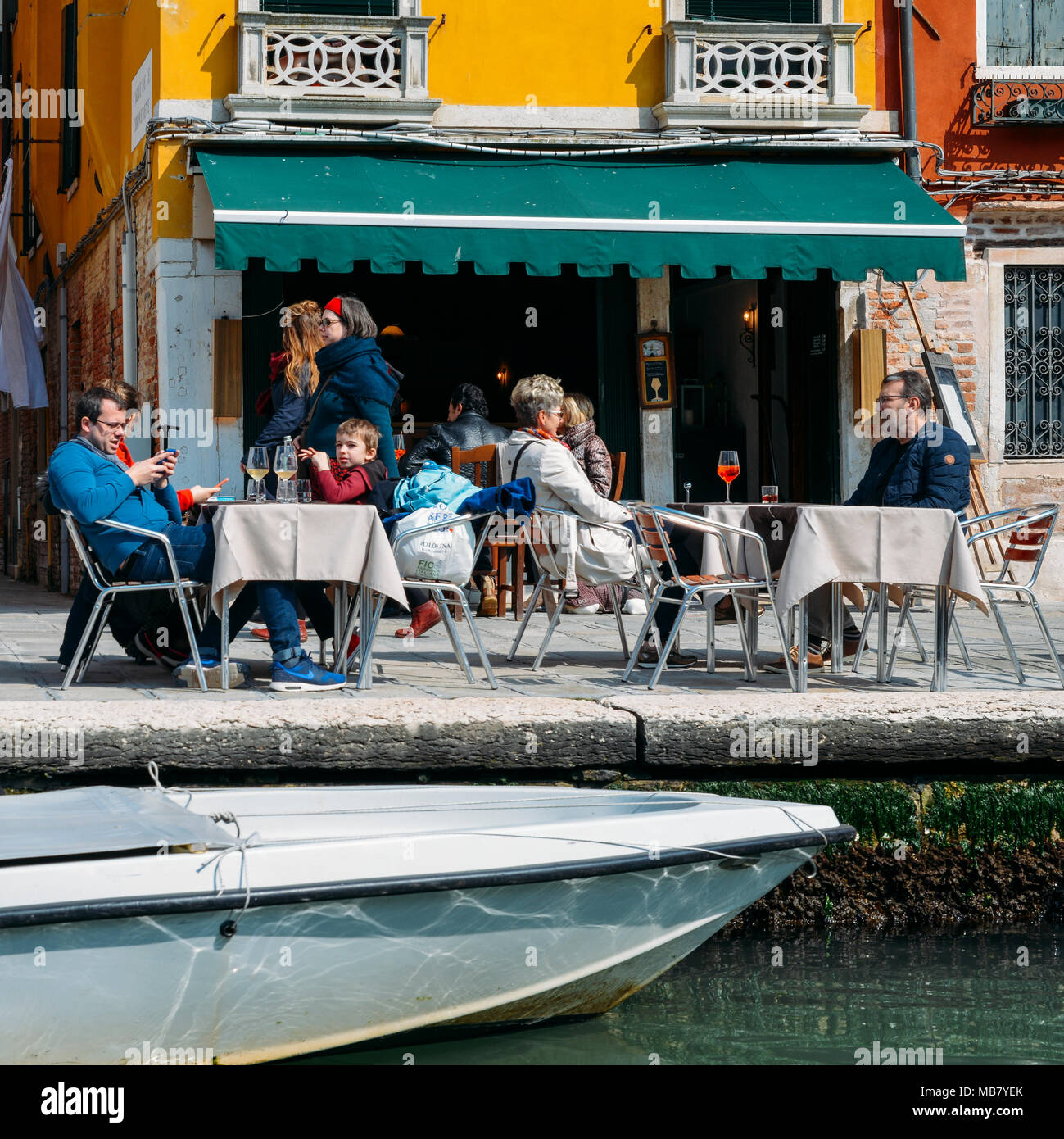 I turisti in una terrazza sul bordo di un canale di Venezia Foto Stock