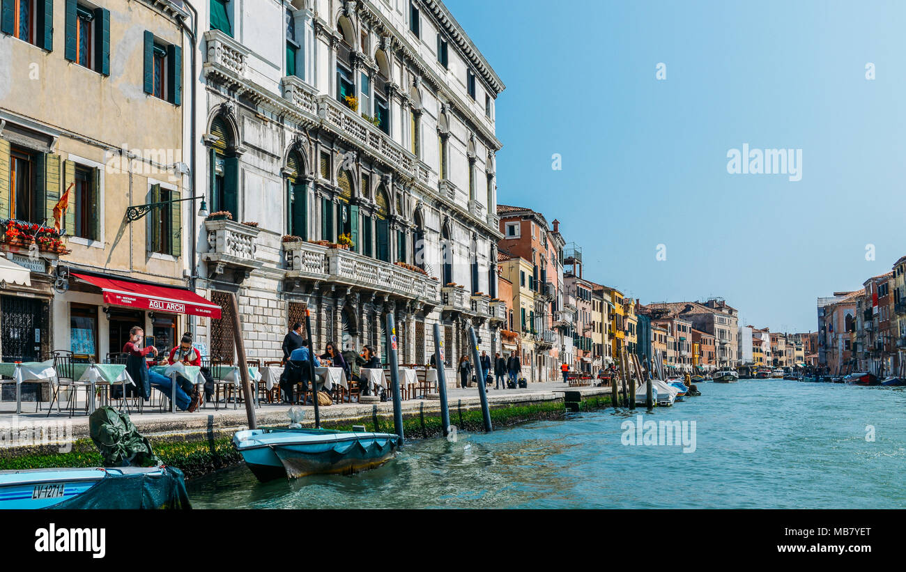 I turisti in una terrazza sul bordo di un canale di Venezia Foto Stock