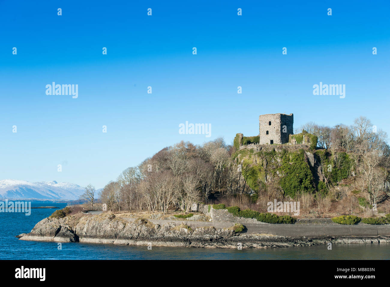 Dunstaffnage Castle & Cappella vicino a Oban sulla costa occidentale della Scozia con montagne innevate della distanza Foto Stock