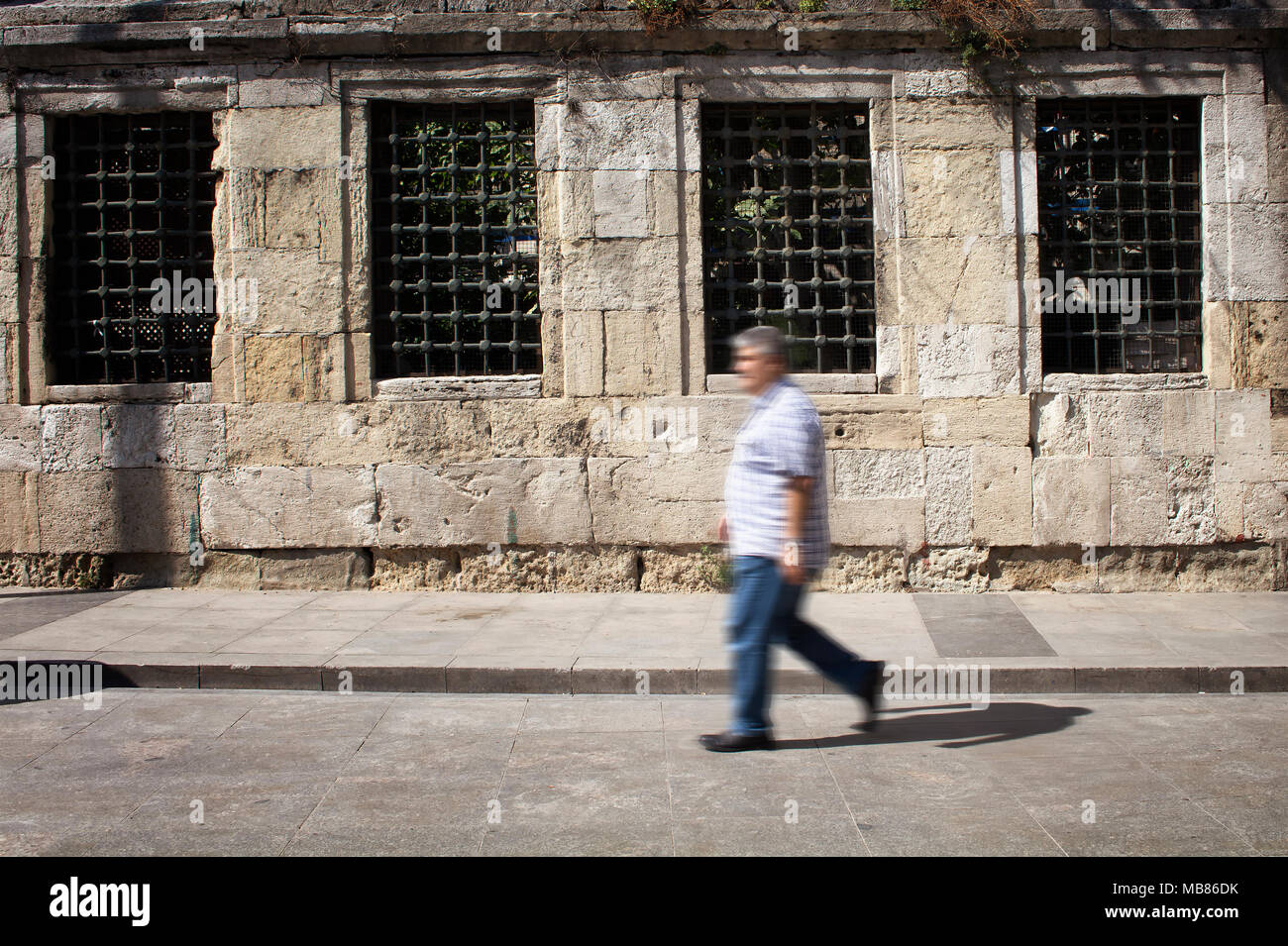 Sfocata immagine del movimento della mezza età uomo a piedi nella parte anteriore della storica, vecchio muro di pietra nel quartiere Eminonu /zona Sirkeci di Istanbul. Foto Stock Sfocata immagine del movimento della mezza età uomo a piedi nella parte anteriore della storica, vecchio muro di pietra nel quartiere Eminonu /zona Sirkeci di Istanbul. Foto Stock