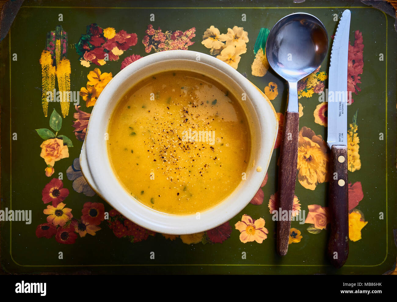 Un rustico di una ciotola di zuppa thgick, cucchiaio e coltello Foto Stock