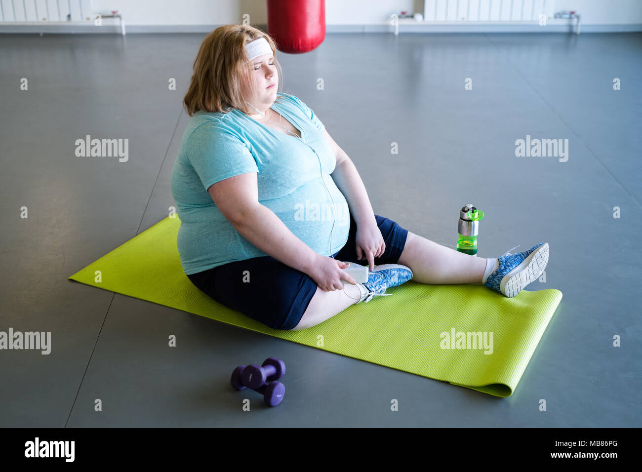 Donna obesa in appoggio dopo allenamento Foto Stock