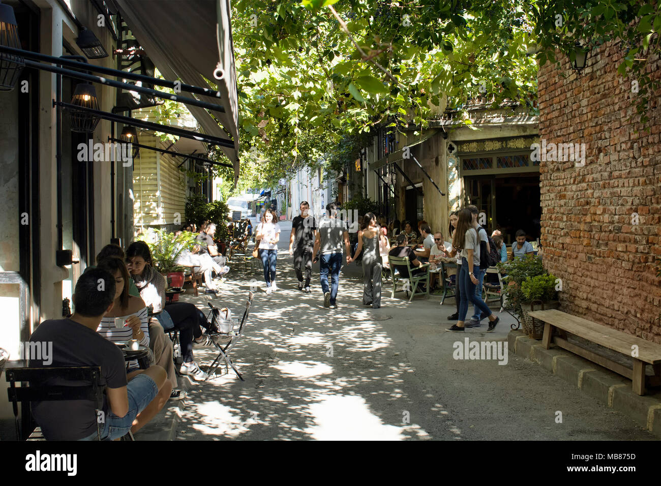 Le persone godono di bel tempo in caffè nel quartiere alla moda, Karakoy a Istanbul. Foto Stock