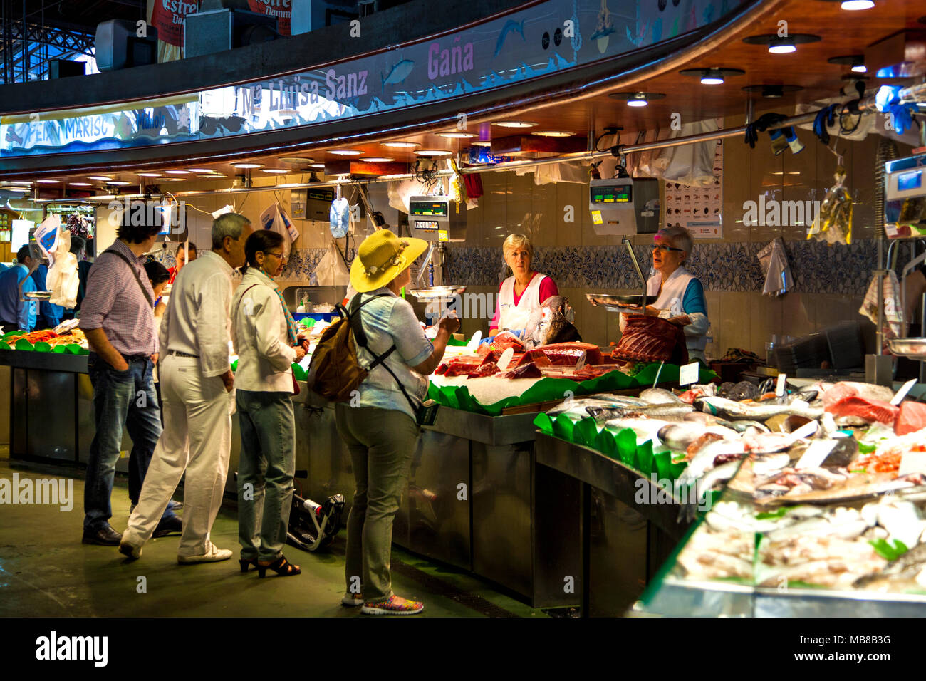 People shopping presso le carni fresche e i frutti di mare si spegne al mercato La Boqueria a Barcellona, Spagna Foto Stock