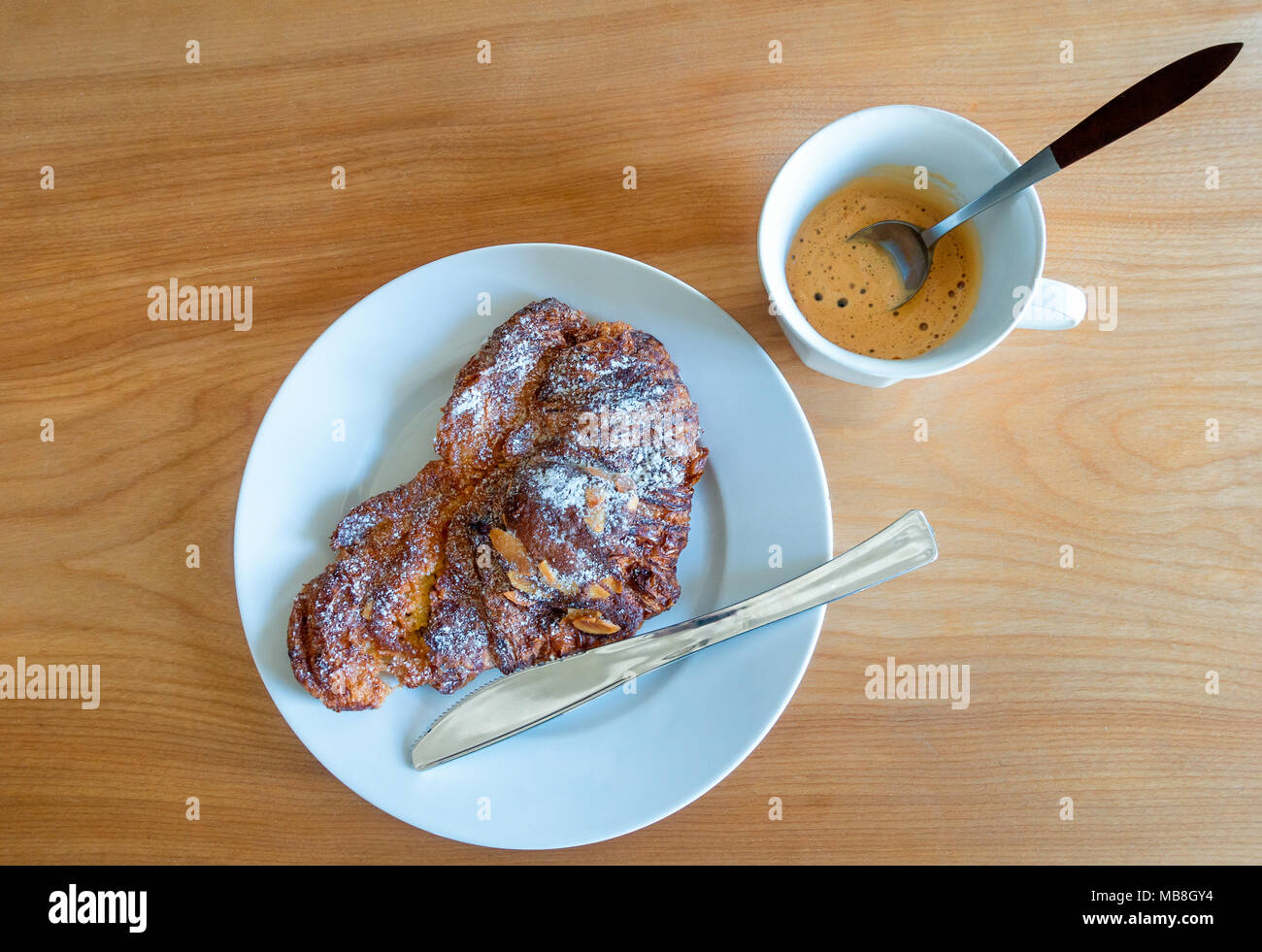 Croissant alle mandorle con caffè espresso, una rinomata prima colazione continentale Foto Stock