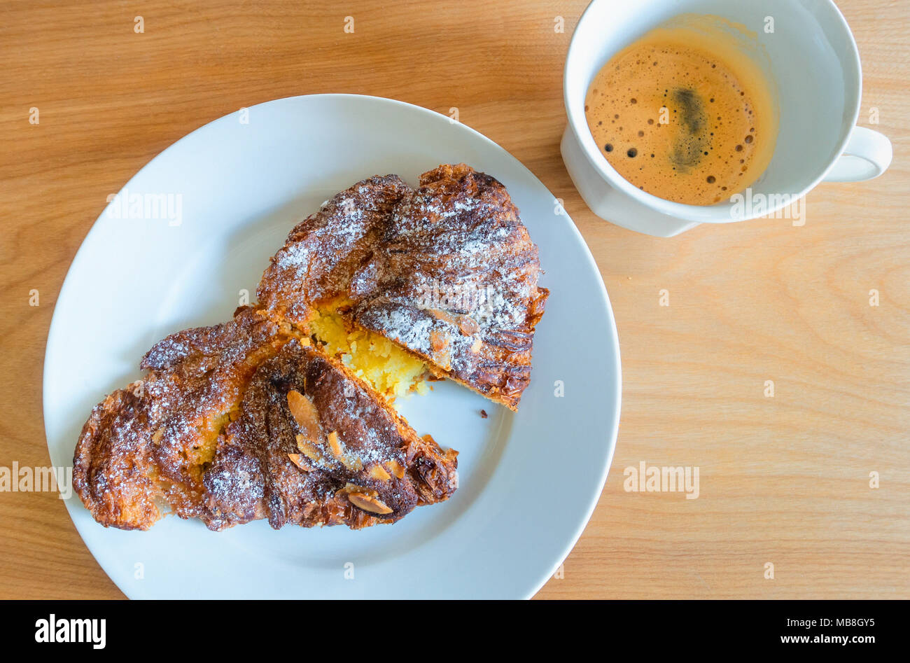 Un croissant alle mandorle e caffè espresso, una rinomata prima colazione continentale Foto Stock