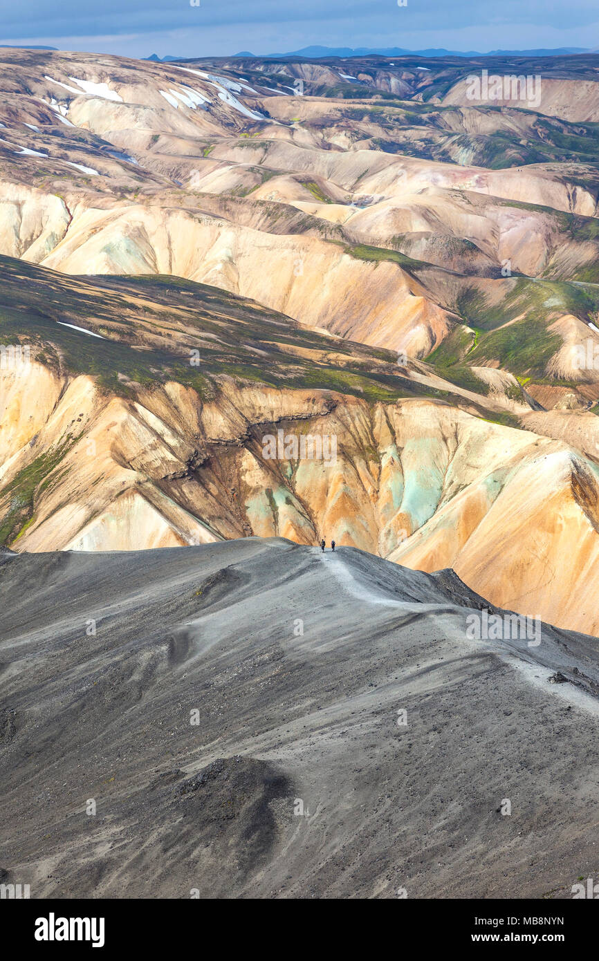 Gli escursionisti Decending la montagna di Blahnukur con un paesaggio di colorate montagne vulcaniche avanti, Landmannalaugar Islanda Foto Stock